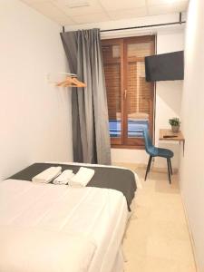 1 dormitorio con 1 cama, 1 silla y 1 ventana en PLAZA HOME en Valencia