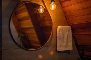a bathroom with a round mirror and a towel at Cabana Arizona no The Country Huts in Novo Gama