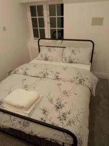 a bedroom with a bed with white sheets and flowers at Inviting Relaxing 2-Bed House-Hampstead-London in London