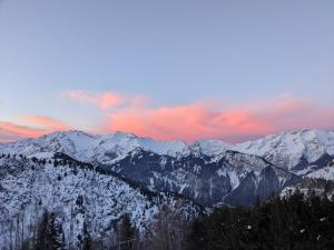 Blick auf schneebedeckte Berge mit Sonnenuntergang in der Unterkunft Ecrin Alpe d'huez in Huez