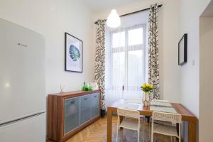 WAWELOVE ROYAL spacious 2 bedroom apt 1 min to Main Sq! في كراكوف: غرفة طعام مع طاولة ونافذة