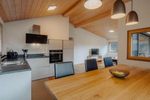 a kitchen and dining room with a wooden table and chairs at Appartement Anemone in Gortipohl