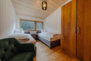 a bedroom with two beds and a couch and a window at Appartement Anemone in Sankt Gallenkirch +39 photos