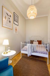 WAWELOVE ROYAL spacious 2 bedroom apt 1 min to Main Sq! في كراكوف: غرفة نوم بسرير وطاولة ومصباح