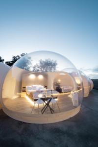 a circular building with a bed and a table at Glamping Balú in Monesterio
