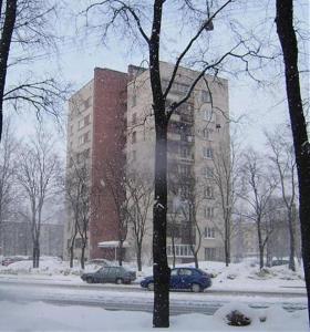 un edificio en la nieve con coches aparcados delante en EvroApartment on Moskovskaya, en San Petersburgo