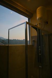 uma casa de banho com um chuveiro e uma janela grande em Eye Catch Kandy em Kandy