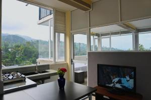eine Küche mit einem Tisch und einem TV in einem Zimmer in der Unterkunft Eye Catch Kandy in Kandy