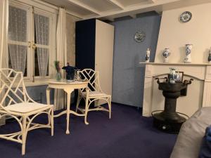 una camera con tavolo, sedie e camino di B&B Petit Chateau a Biervliet