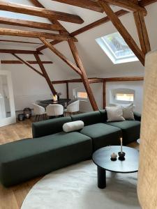 a living room with a green couch and a table at Mosel-Charm - Urige Dachgeschosswohnung - 3 Schlafzimmer für 6 Personen - Liebevoll renoviert & gemütlich in Ürzig