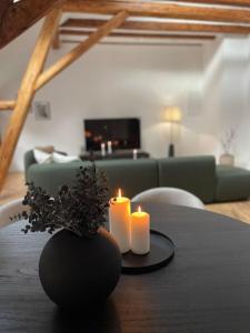 two candles on a table in a living room at Mosel-Charm - Urige Dachgeschosswohnung - 3 Schlafzimmer für 6 Personen - Liebevoll renoviert & gemütlich in Ürzig