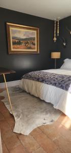 a bedroom with a bed and a painting on the wall at La Casa Rossa - free parking in Cheltenham