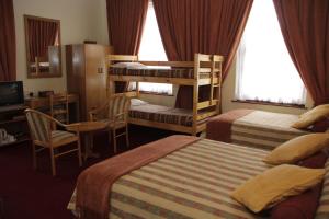 a hotel room with two bunk beds and a television at Laings Lodge in Laingsburg