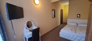 Zimmer mit einem TV und einem Bett mit einem Spiegel in der Unterkunft Haus am Berg in Vartop