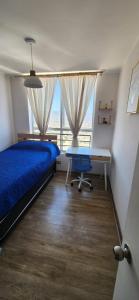 a bedroom with a bed and a desk and a window at Valpo y su encanto, a pasos de Viña y la costa in Viña del Mar +12 photos