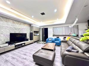 ein großes Wohnzimmer mit Sofa und TV in der Unterkunft Hi House in Toucheng