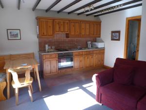 a kitchen with wooden cabinets and a table and a couch at Ashfield House in Pateley Bridge