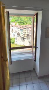 ein Fenster in einem Zimmer mit Blick auf ein Gebäude in der Unterkunft Vue exceptionnelle aux portes du Vercors in Pont-en-Royans