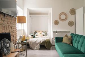 a living room with a green couch and a bed at Livestay-Studio Apartments in London Green Lanes in London