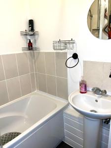 a bathroom with a bath tub and a sink at Comfortable and convenient 1-Bed Apart in Romford in Romford