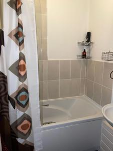 a bathroom with a tub and a sink at Comfortable and convenient 1-Bed Apart in Romford in Romford