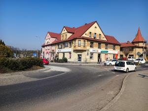 a white car is parked in front of a building at Pokoje Goscinne in Orzesze