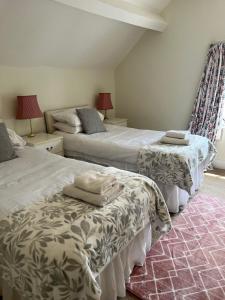 a bedroom with two beds and two tables at The Cottage in Abergavenny