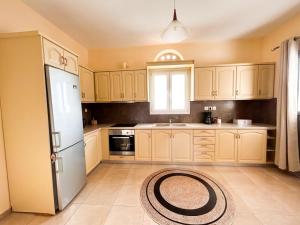 a kitchen with white cabinets and a white refrigerator at Aegean View House in Agios Ioannis