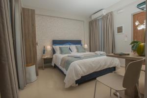 una camera con un grande letto e una scrivania di Athina Residence a Lentas