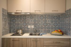a kitchen with a sink and a bowl of fruit at Athina Residence in Lentas