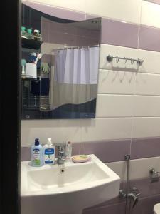 y baño con lavabo blanco y espejo. en Khatai Apartment en Bakú