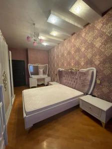 1 dormitorio con cama y pared en Khatai Apartment en Bakú