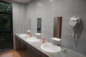 ein Badezimmer mit zwei Waschbecken und einem Telefon an der Wand in der Unterkunft Feel good pinklao in Bangkok