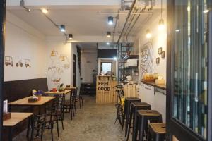 Feel good pinklao في بانكوك: مطعم فيه طاولات وكراسي في الغرفة