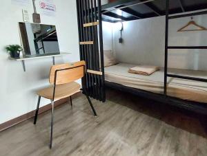 バンコクにあるFeel good pinklaoの二段ベッド2台と椅子が備わる客室です。