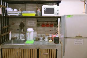 eine Küche mit einer Spüle, einer Mikrowelle und einem Kühlschrank in der Unterkunft Feel good pinklao in Bangkok