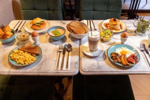 a table with plates of breakfast food on it at Mister Highland Hotel in Amsterdam +96 photos