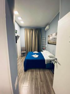 a bedroom with a blue bed in a room at Rodinó rooms in Naples