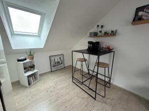 una habitación con dos taburetes y una mesa en un ático en CHAMBRE PRIVÉE dans une maison, en Argenteuil