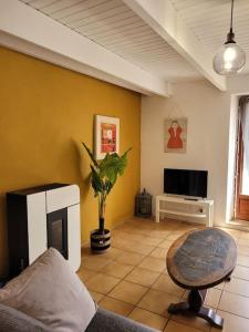 クロゾンにあるChaleureux Penty, bord de mer, Pointe de Dinanのソファとテレビのあるリビングルーム