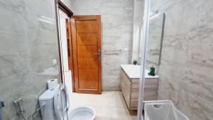 La salle de bains est pourvue de toilettes, d'un lavabo et d'un miroir. dans l'établissement Wide Family Apartment in the new Center of Casablanca, à Casablanca