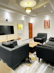 sala de estar con sofás y TV de pantalla plana. en Appartements meublés - Cozy House Bénin en Cotonú
