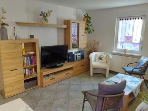 a living room with a television on a wooden entertainment center at Fewo Rosi in Brotterode-Trusetal