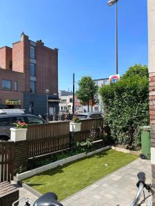 a backyard with a fence and a yard with grass at Enjoy a private room in the center of Antwerpen in Antwerp