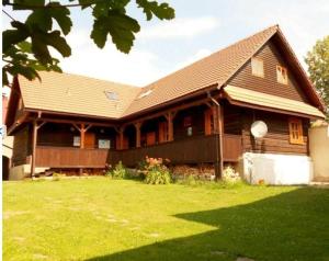 a large wooden house with a green yard at Penzion Hron in Brezno