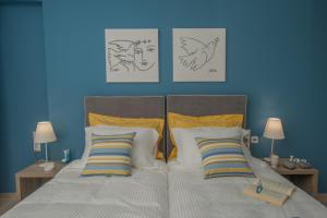 レンタスにあるAthina Residenceのベッドルーム1室(青い壁のベッド2台、ランプ2つ付)