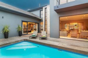 a house with a swimming pool next to a house at Luxury Views + Excellence - Pezula no Loadshedding in Knysna