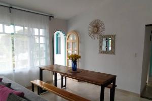 una sala de estar con una mesa y un jarrón con flores. en Casa Turística Líbano, en Líbano