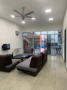 a living room with couches and a ceiling fan at 365 Homestay in Kaki Bukit