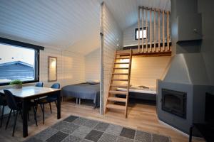 a tiny house with a staircase and a bedroom at Aava Sky Village Aurinkomaja in Aavasaksa